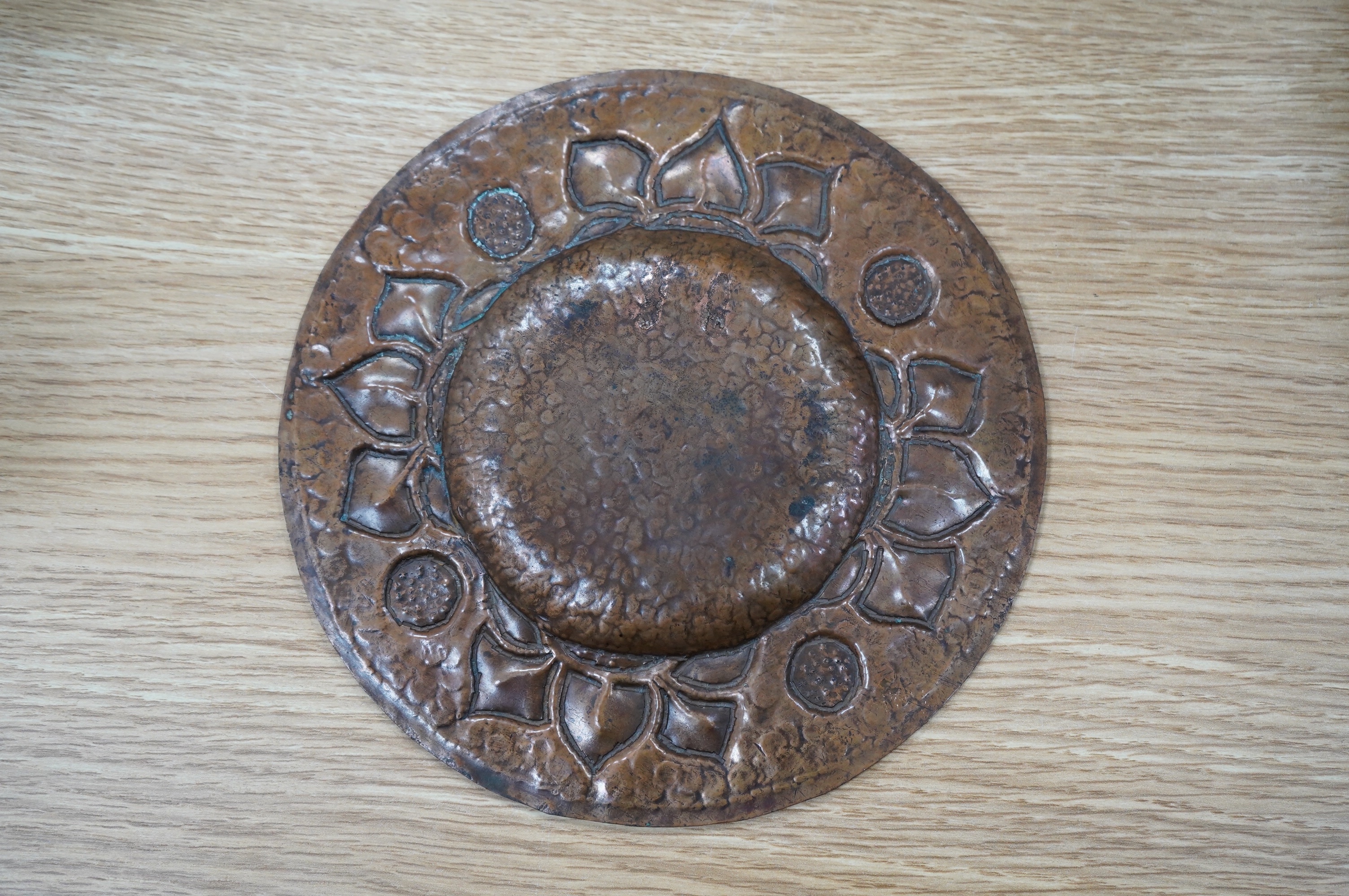 An Arts & Crafts embossed copper dish, 18cm in diameter. Condition - fair to good